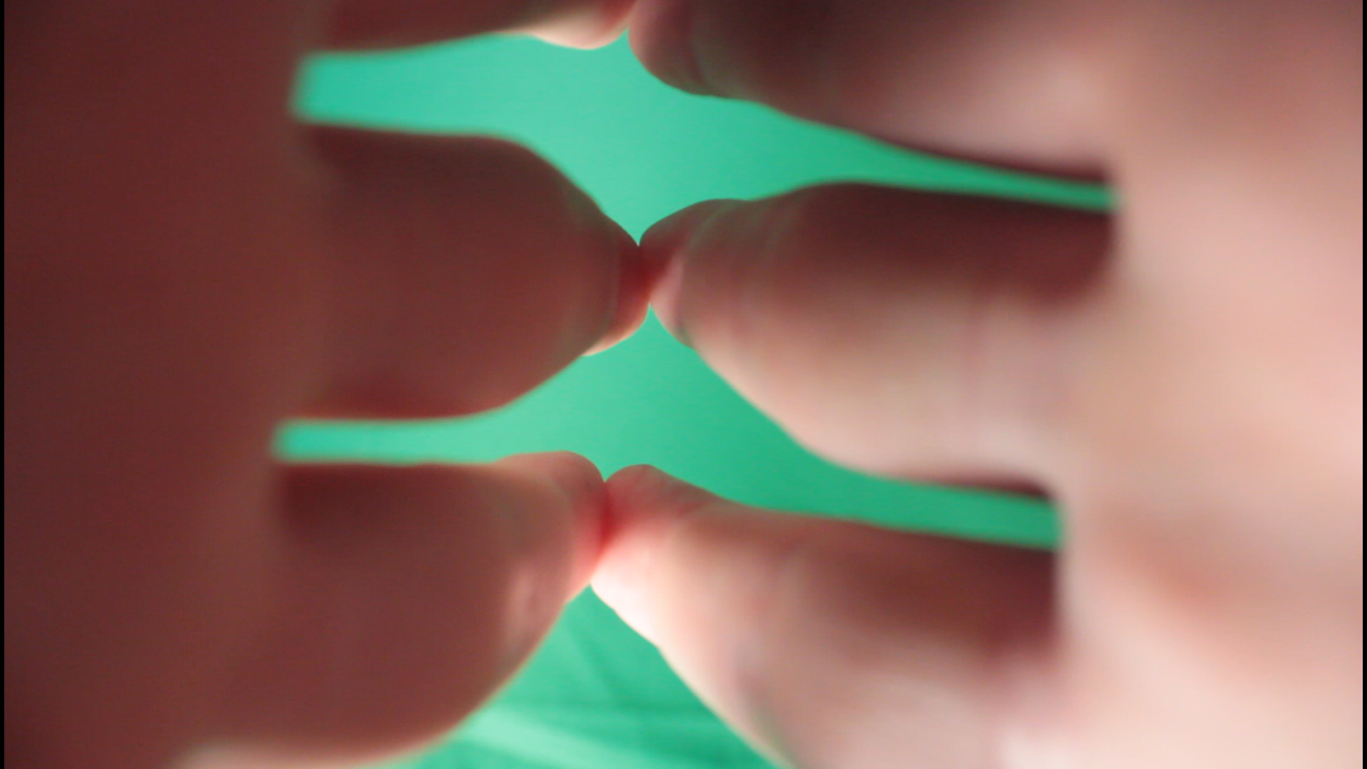 Two hands touch at the fingers, against a green background