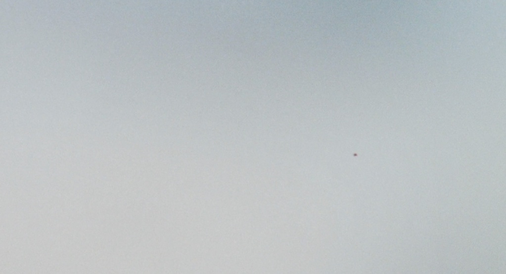 film still, a blue but hazy sky, a small object is flying on the right, it's too small to tell what it is
