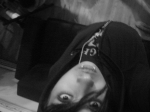 black and white photo of a goth young person looking at the camera upside down