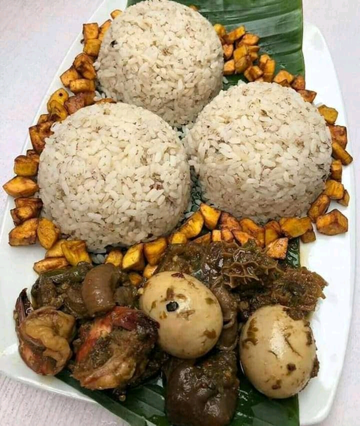 rice balls, plantain, stew on a large leaf and plate