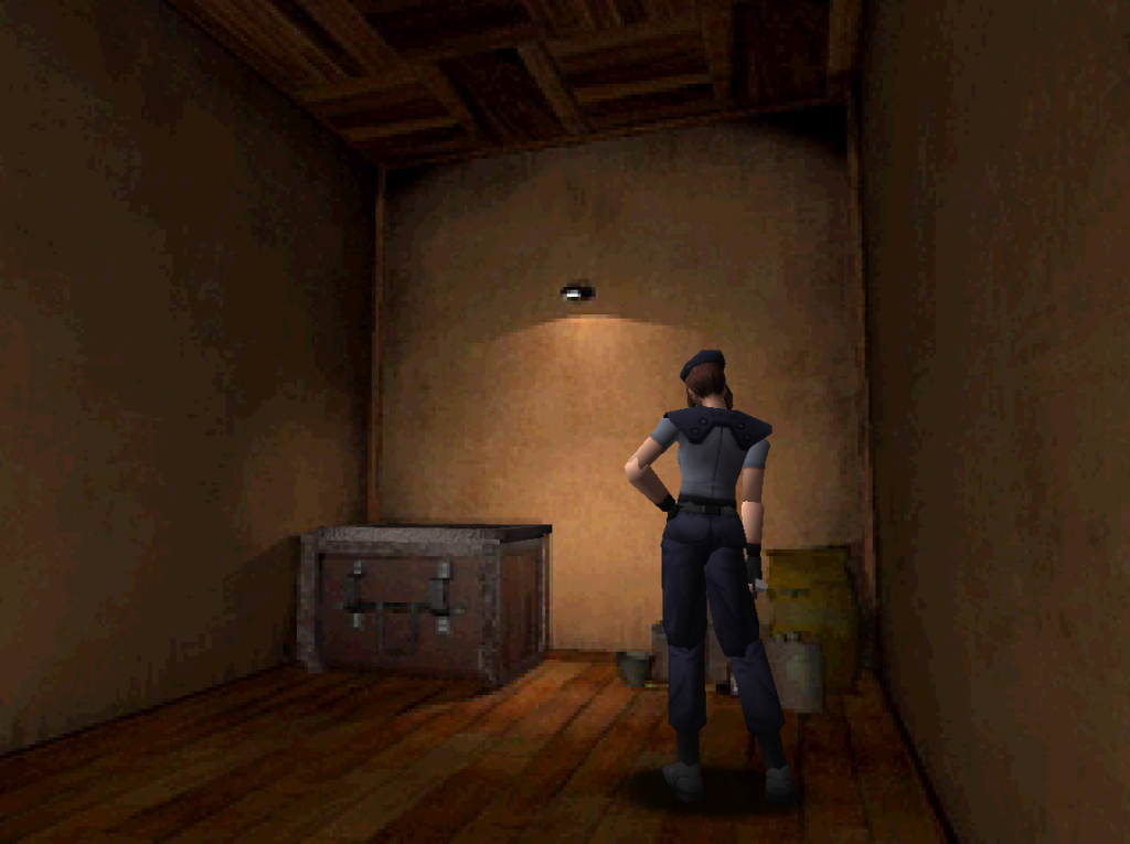 A screenshot from Resident Evil (1997). The player character, Jill Valentine, stands with her hand on her hip in a barely furnished room. There’s a box for inventory items and a pile of fertiliser in the corner.