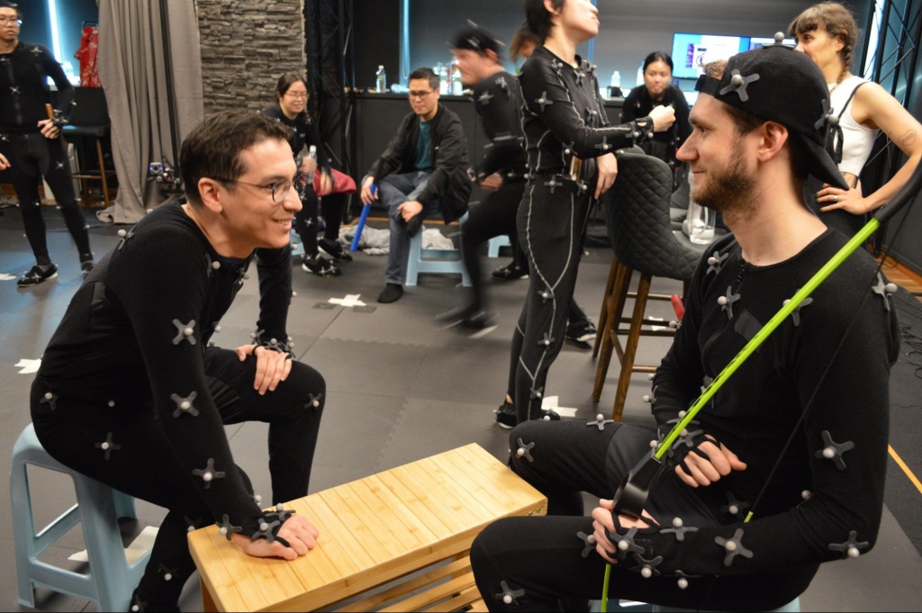 Actors in motion capture suits sitting casually talking