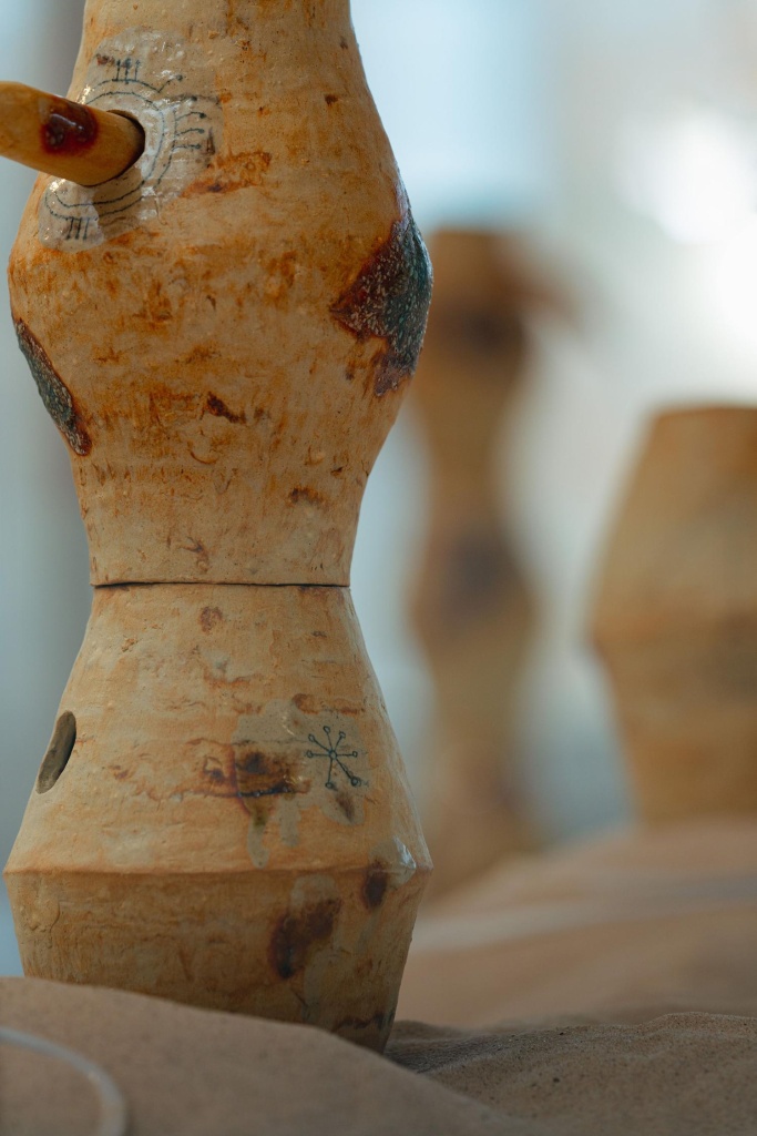 Close up on a pot sculpture with symbols and burns etched onto the side