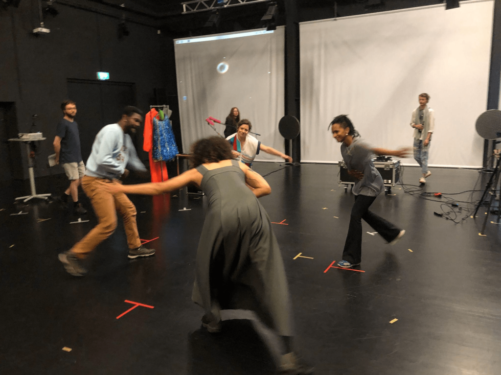 four people in a digital movement recording studio performing capoeira lunges