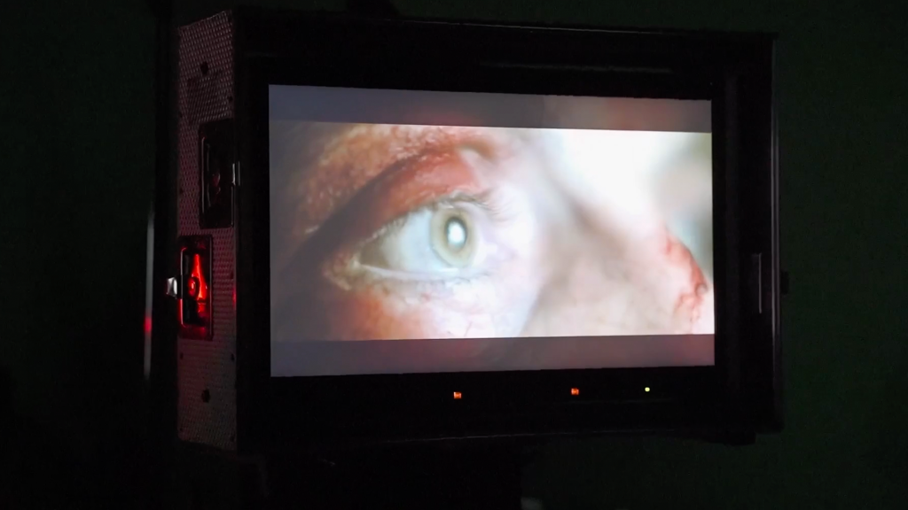 an eye on a movie set monitor in a dark space