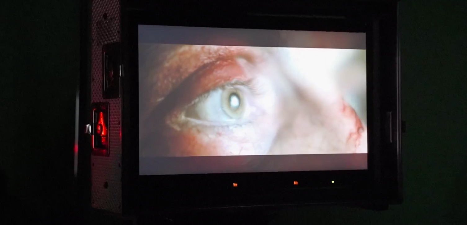an eye on a movie set monitor in a dark space