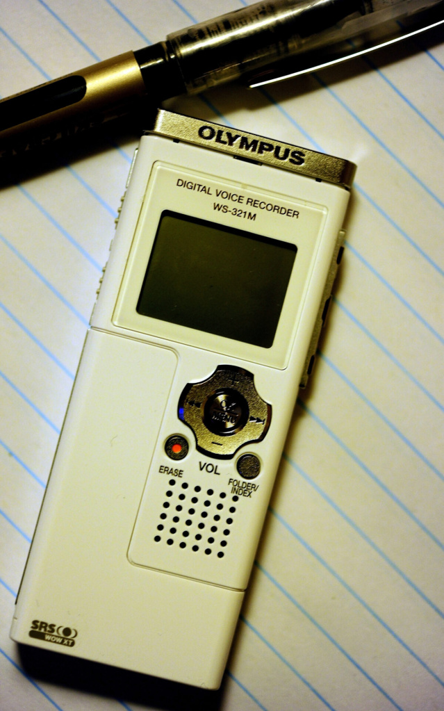 a digital recorder and pen on writing pad